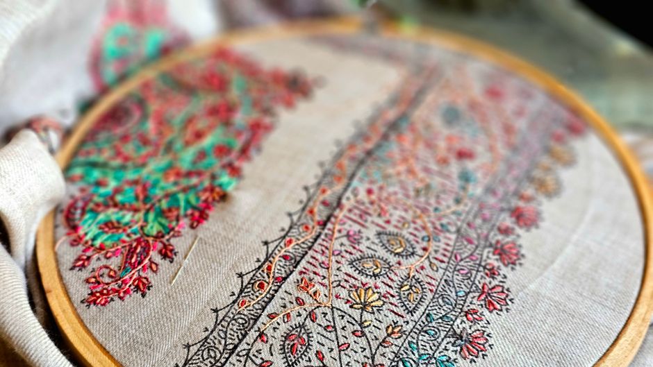Colorful hand embroidery in progress on a fabric hoop, showcasing detailed craftsmanship.